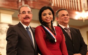 El presidente Medina, la procuradora fiscal del Distrito Nacional, Yeni Berenice Reynoso, al recibir la medalla de plata. [Crédito de imagen: Presidencia]